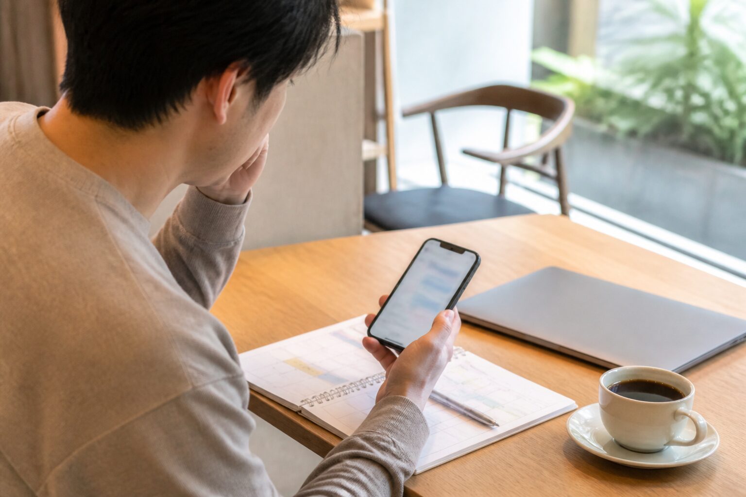 副業の予定表とスマートフォンを確認する男性