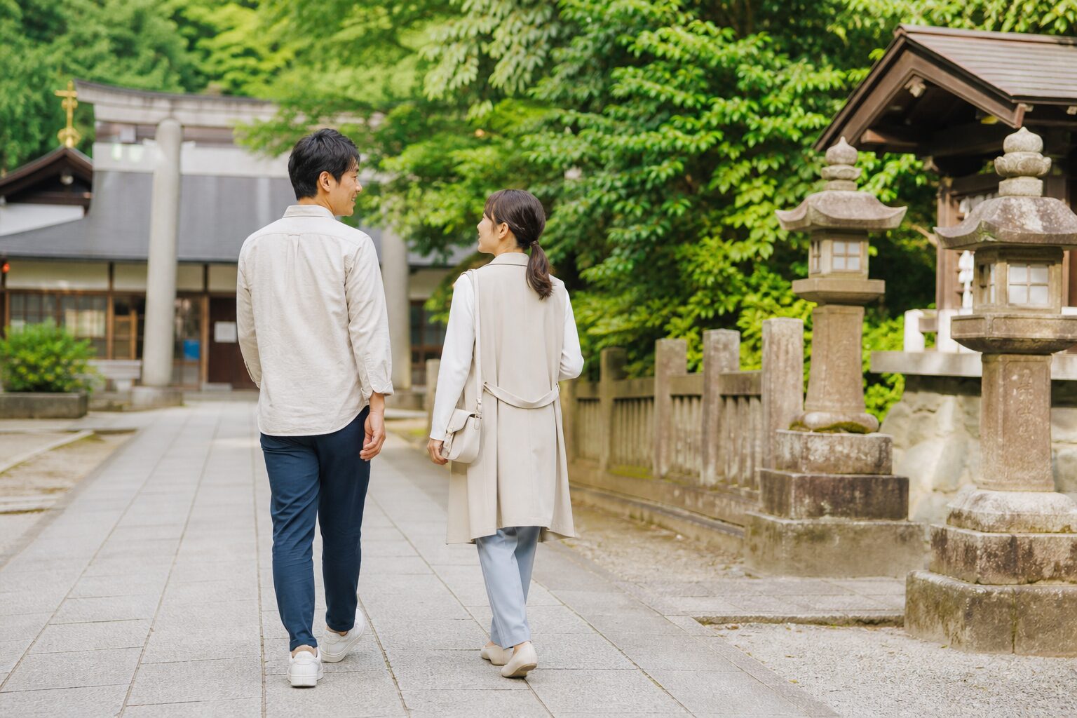 神社の境内を自然な距離で歩く初デートの男女