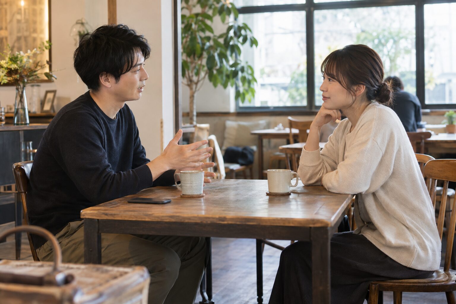 カフェで向かい合い、相手の話を落ち着いて聞く二人